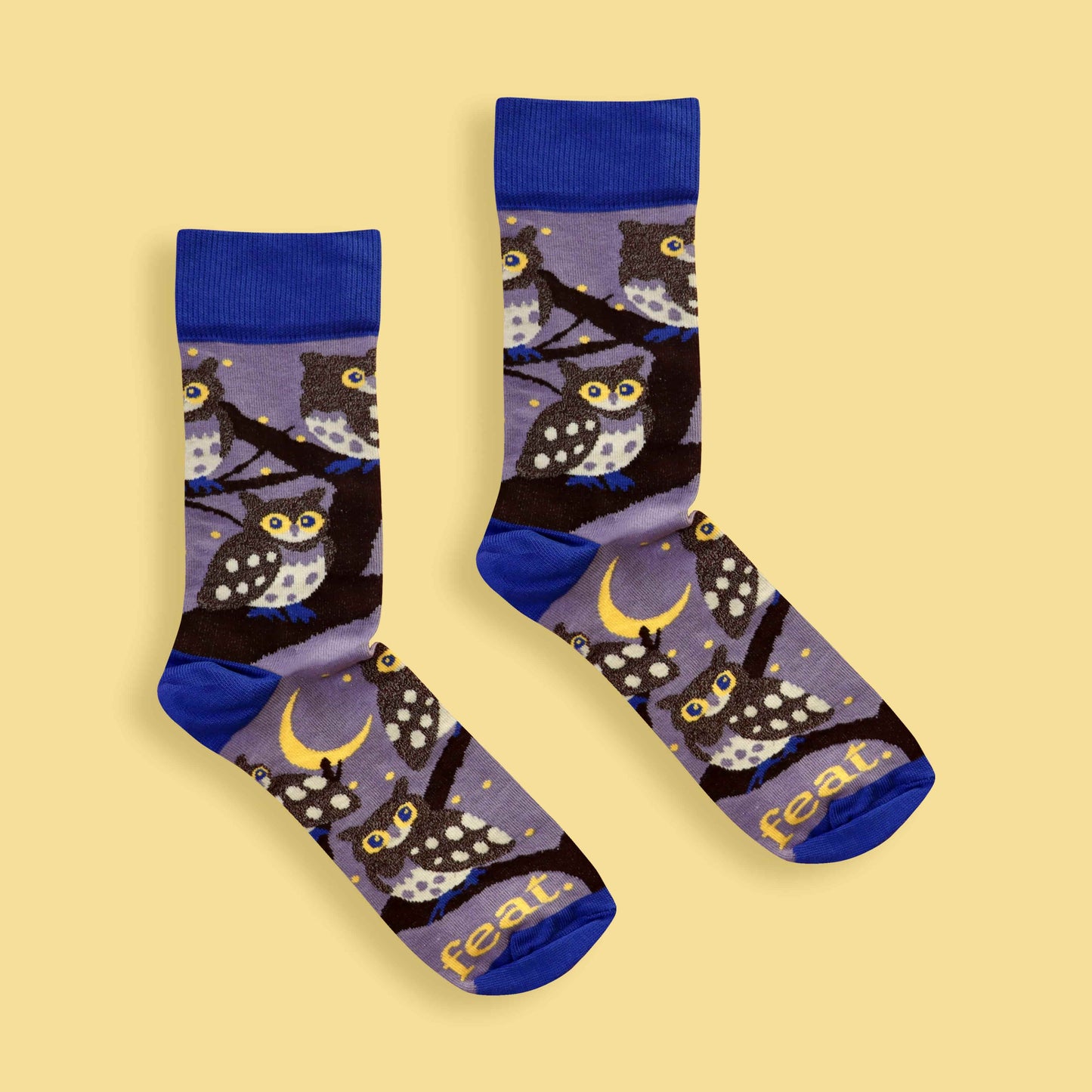 Pair of socks with owl pattern on a yellow background