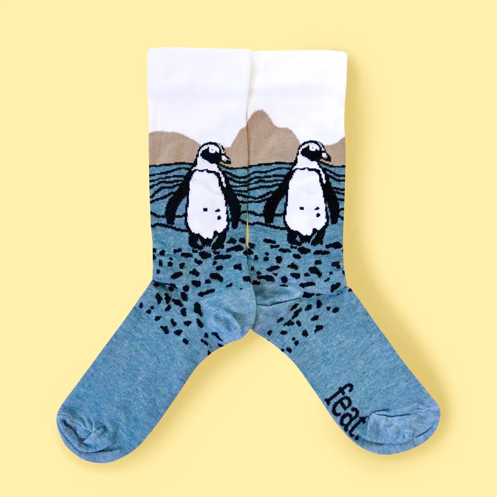 Unisex Penguin Rock socks on yellow background