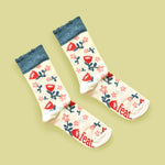 Cream protea frill socks with green background and diagonal layout