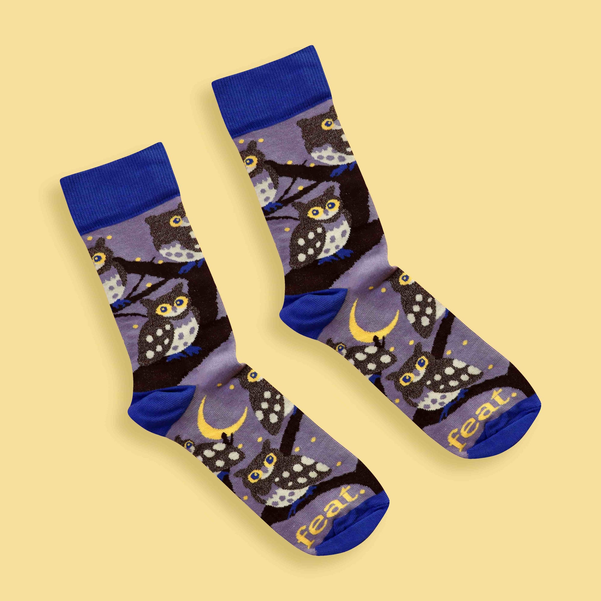 Pair of socks with owl pattern on a beige background
