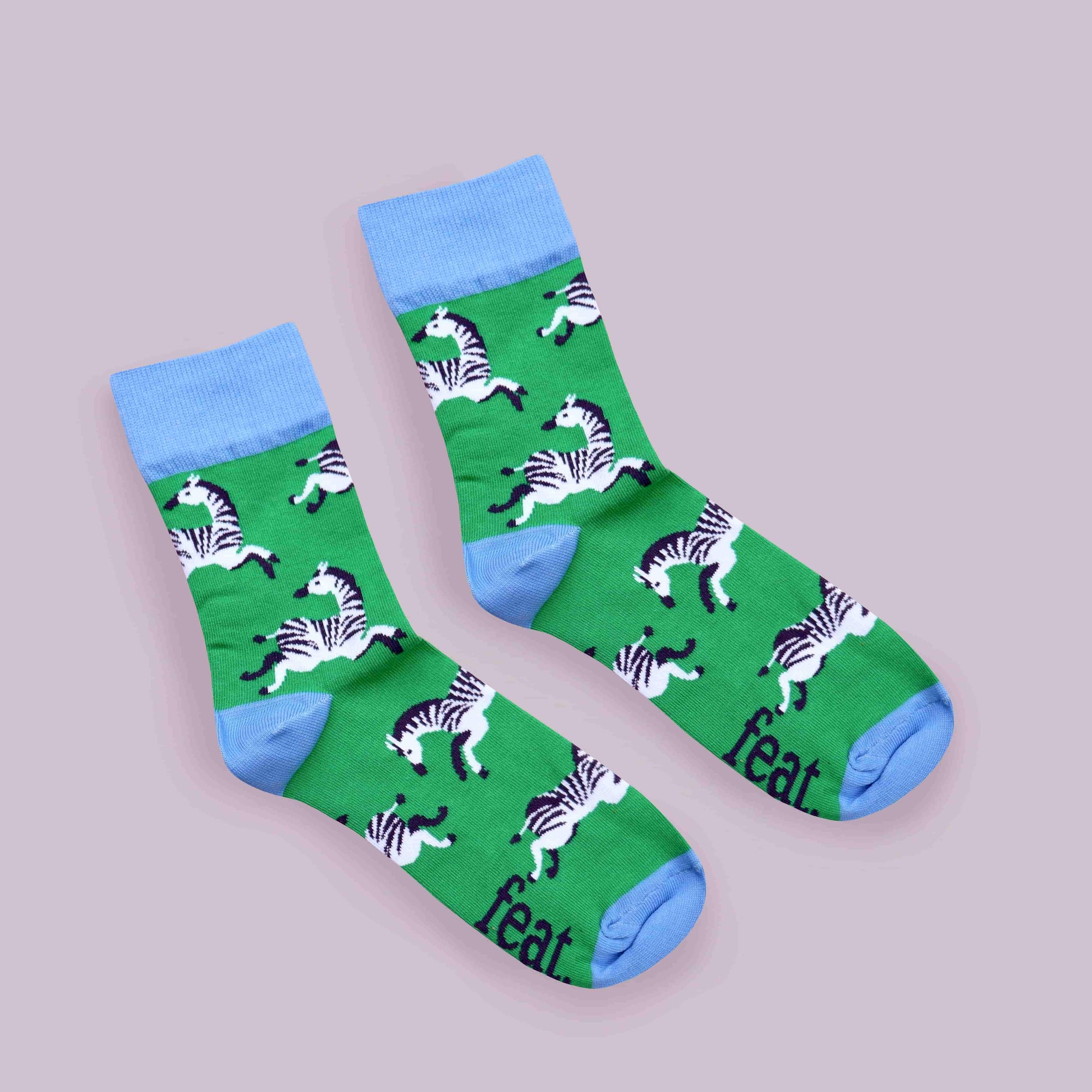 Green zebra socks lilac background diagonal layout